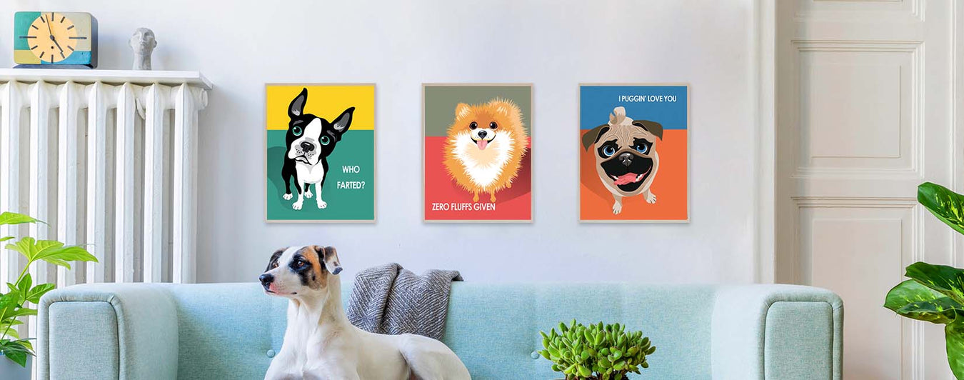 Three dog graphic art prints on a wall behind a dog sitting on a blue couch